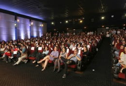 Foto mostra auditório com plateia lotada.