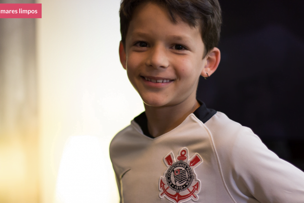 Foto mostra criança sorrindo com camiseta do Corinthians