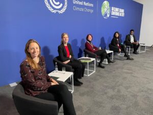Foto mostra várias pessoas sentadas durante painel sobre litigância climática na COP