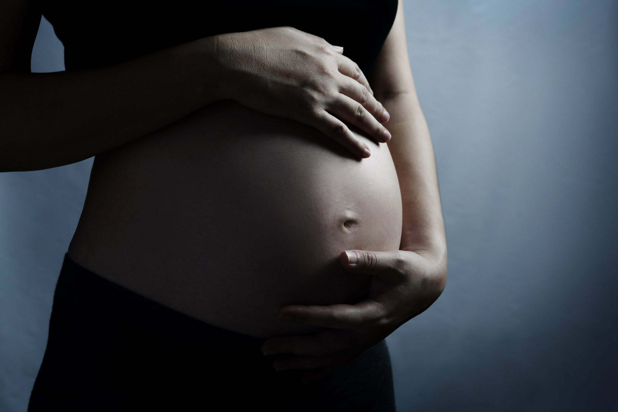 Foto da barriga de uma mulher grávida, em referência à discussão sobre a garantia de direitos de gestantes e mães no sistema prisional e socioeducativo