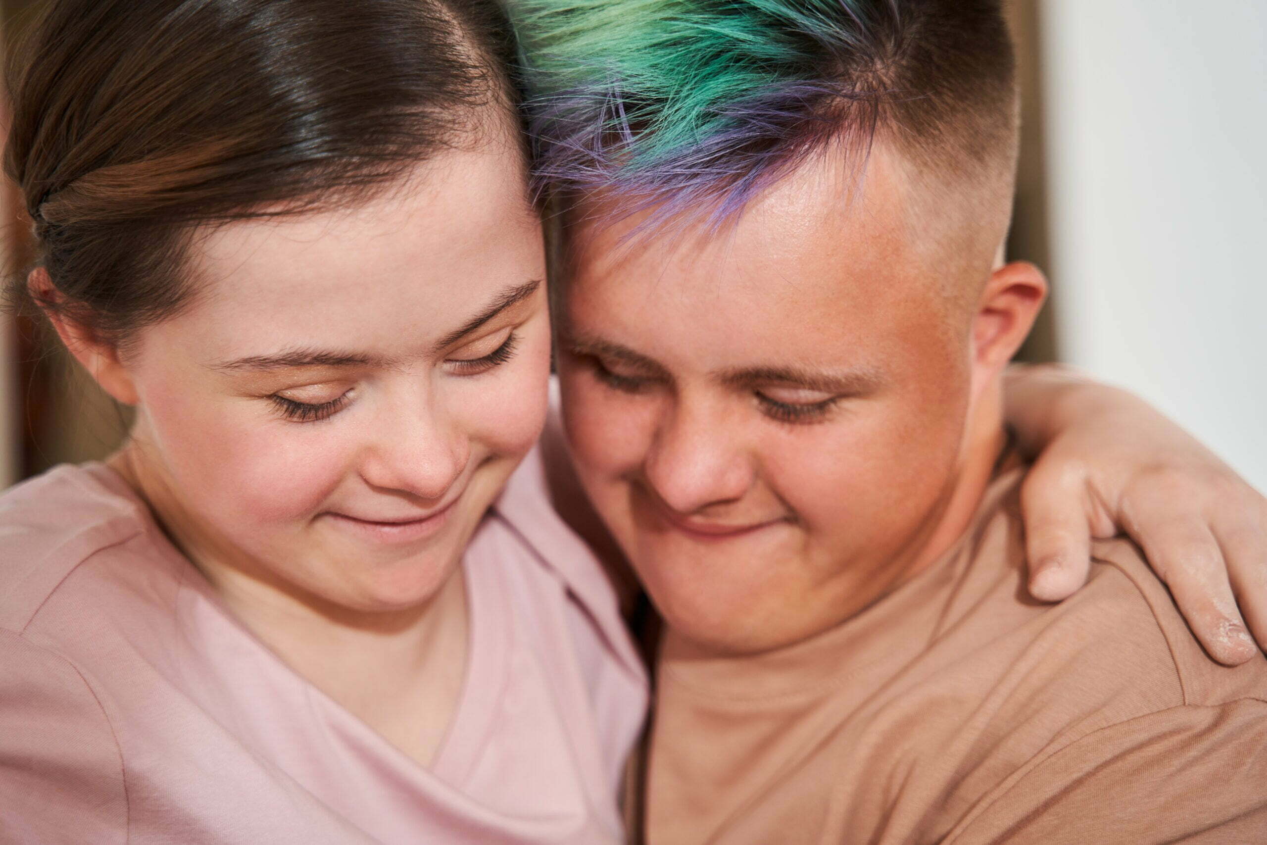 Memantina e síndrome de Down: na foto, dois jovens brancos com síndrome de Down se abraçam e olham para baixo