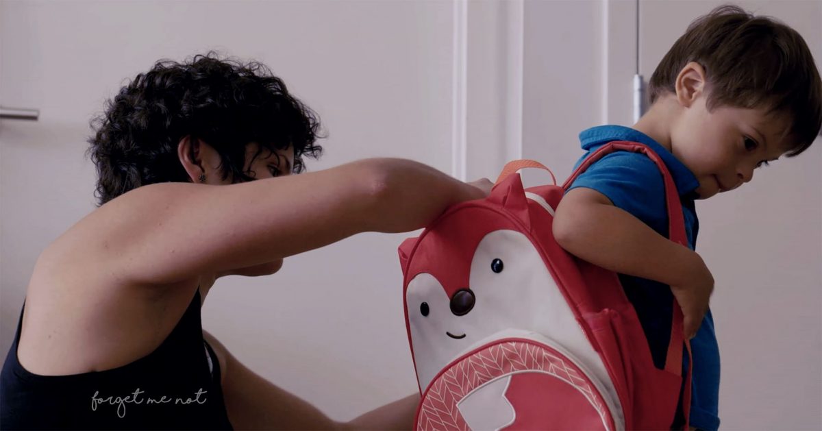 Cena do filme Um Lugar Para Todo Mundo. Na imagem, Emilio, uma criança com síndrome de Down, coloca uma mochila nas costas e se prepara para ir à escola com a ajuda de sua mãe.