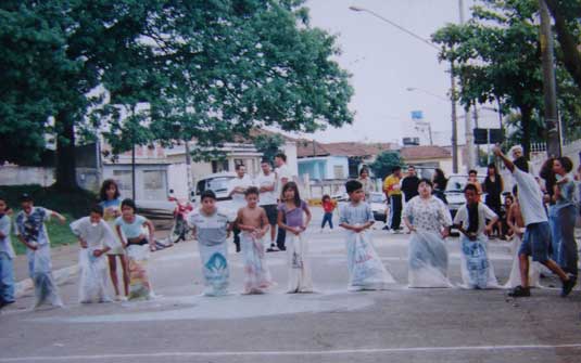Ruas de Lazer: na imagem, crianças brincam de corrida de saco em uma rua.