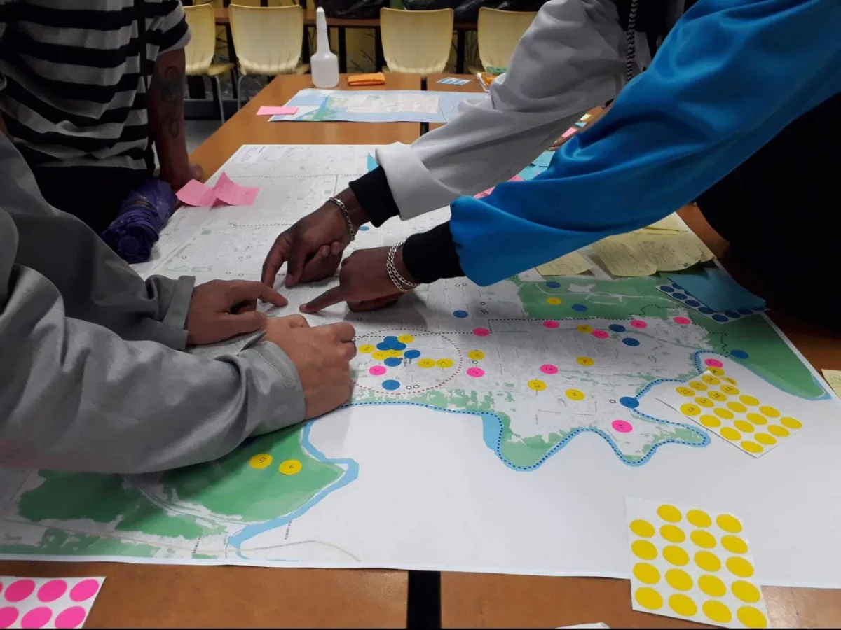 Na foto, grupo analisa um grande mapa do Jardim Pantanal colocado sobre uma mesa.