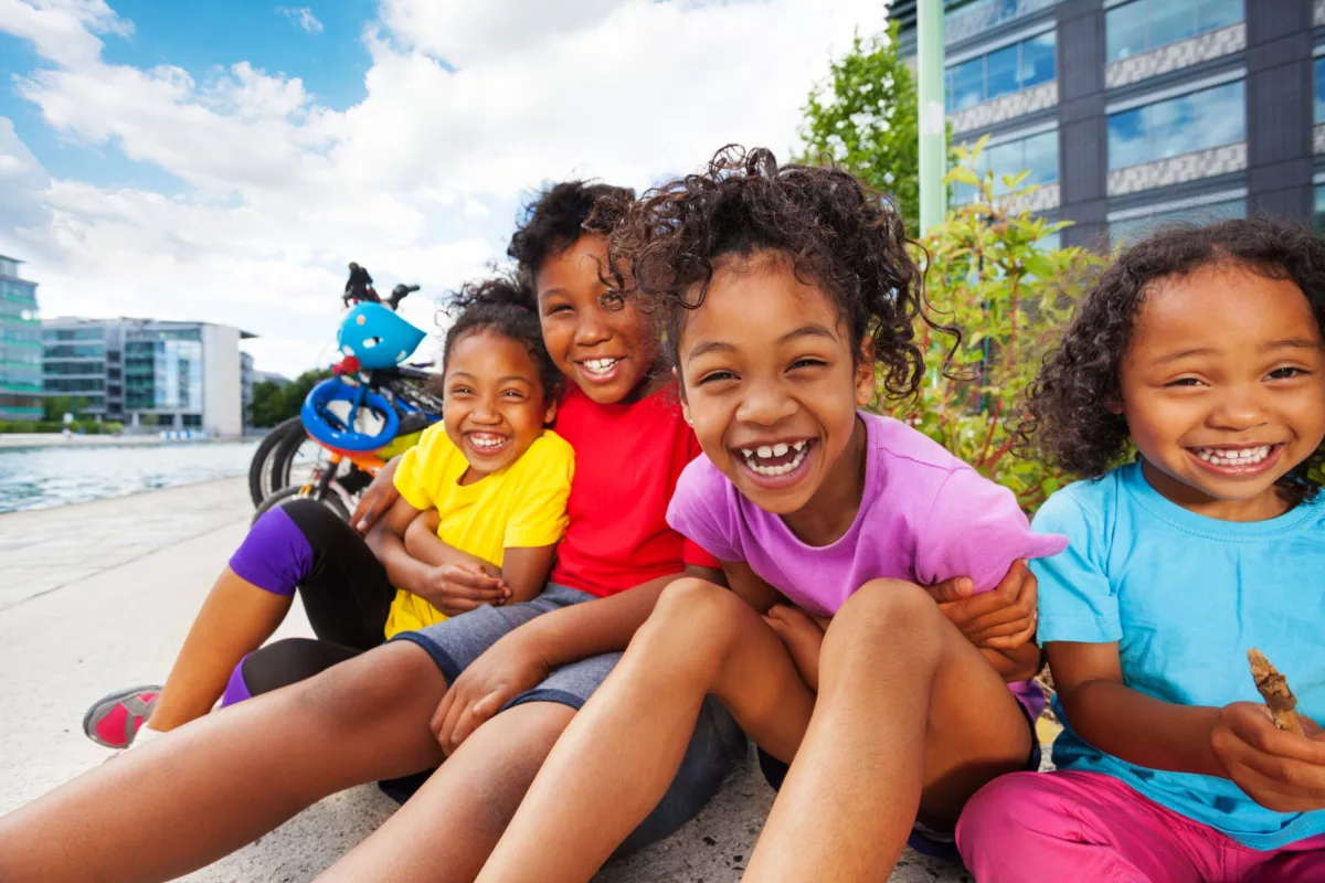 Responsabilidade de empresas com os direitos das crianças: na foto, quatro crianças negras sorriem para a câmera.
